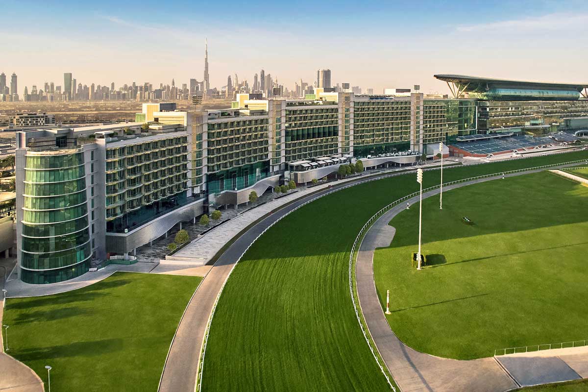 Aerial view of The Meydan Hotel and racecourse with Dubai skyline and Burj Khalifa