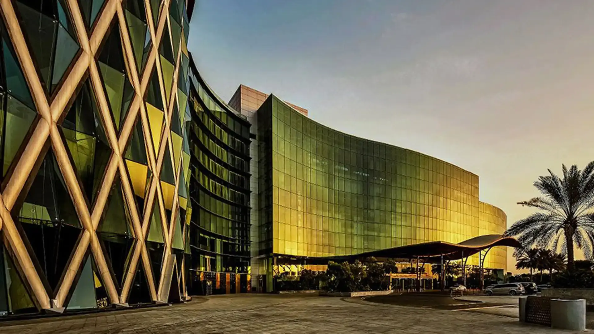 Meydan Hotel exterior with signature gold diamond-lattice facade at sunset